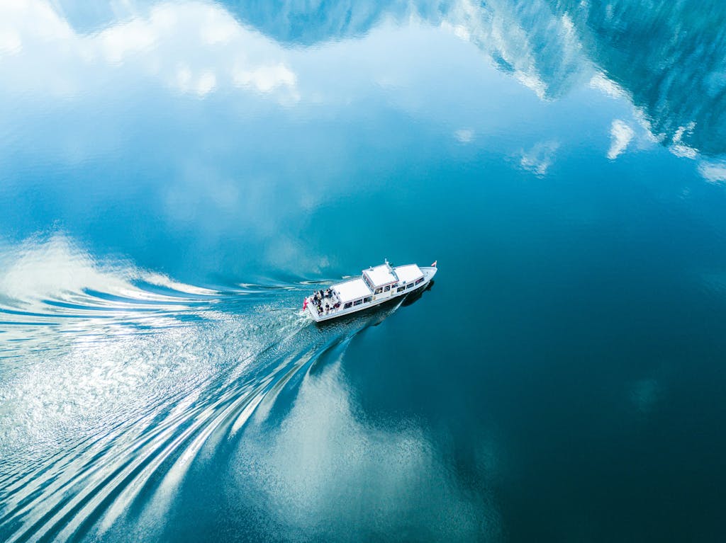 A boat traveling through the water in front of mountains