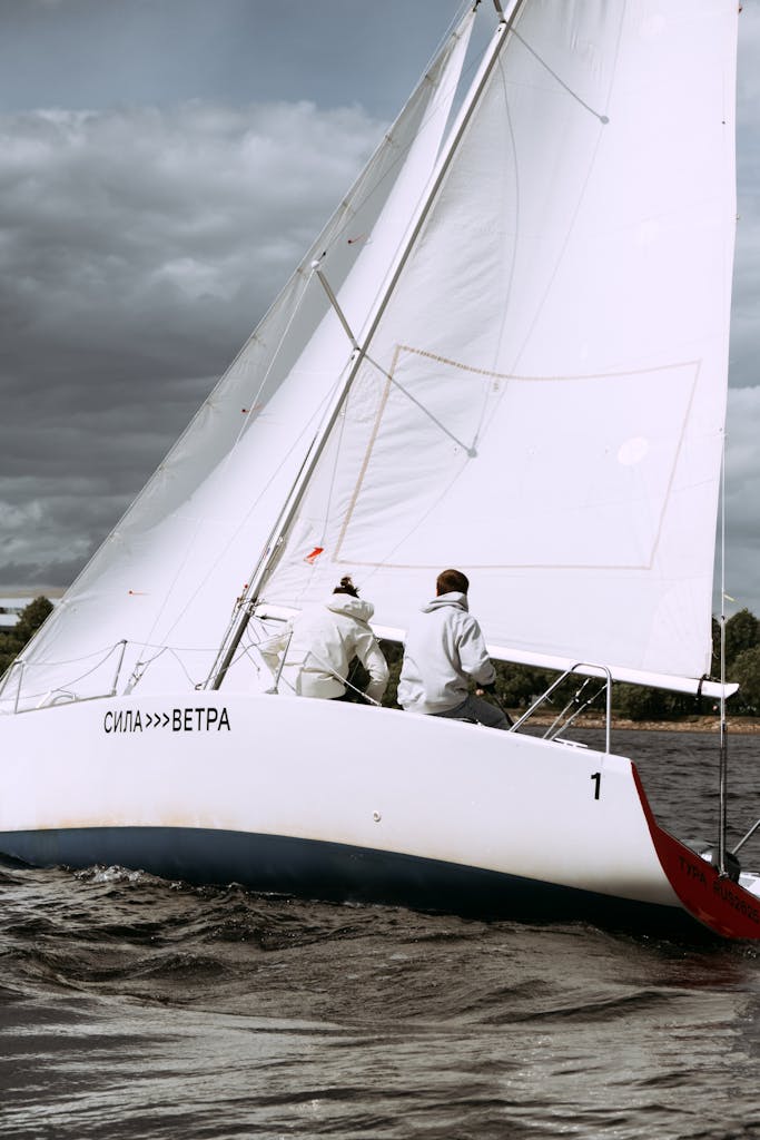 Man in White Shirt Sitting on White Sailboat