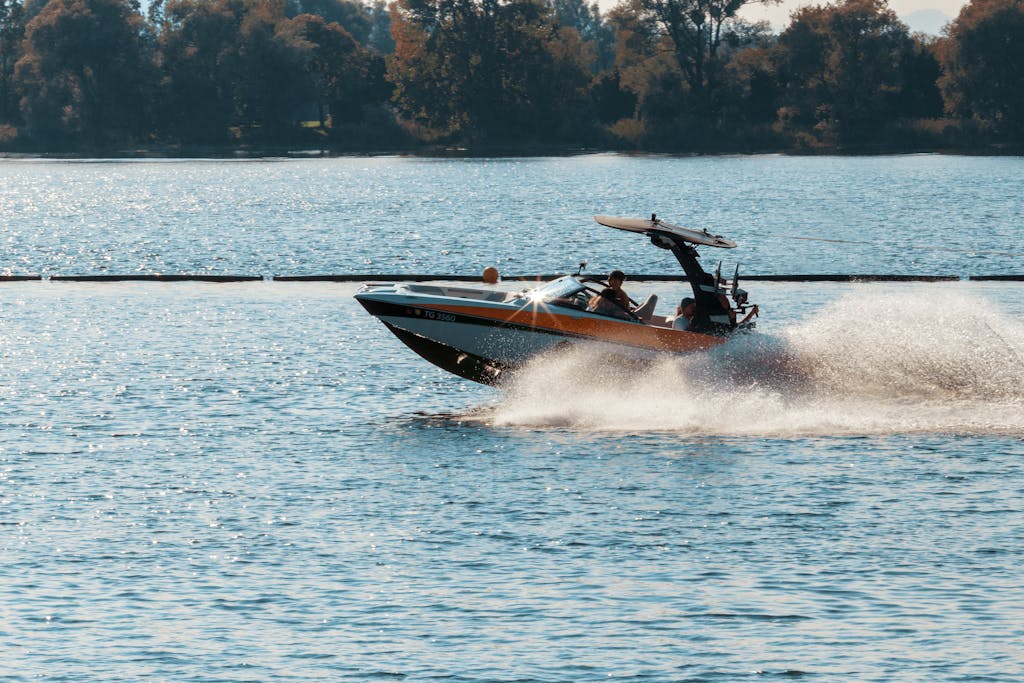 Person Driving Black and Orange Speedboat