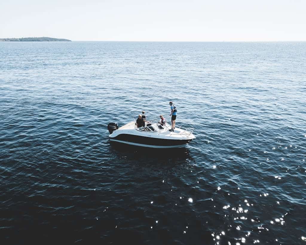 Three Person on White Motorboat at Daytime