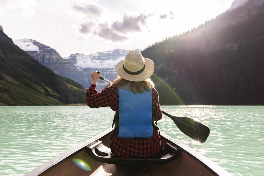 A Woman Paddling A Boat In The Lake