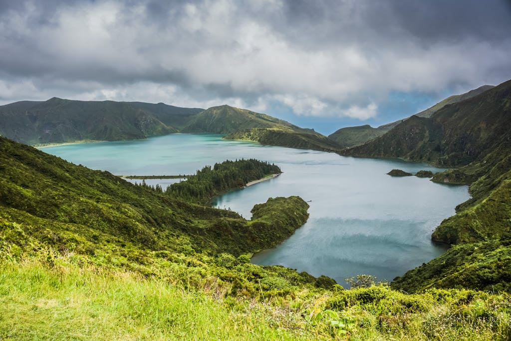 Blue Lake Behind Green Mountain Under White Clouds