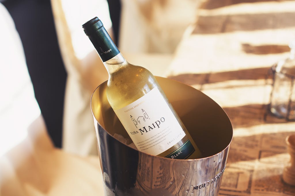 A bottle of Viña Maipo white wine elegantly chilled in an ice bucket on a dining table.