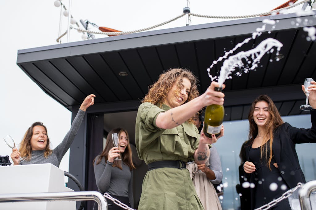 A group of joyful friends celebrating with champagne on a boat in Portugal.