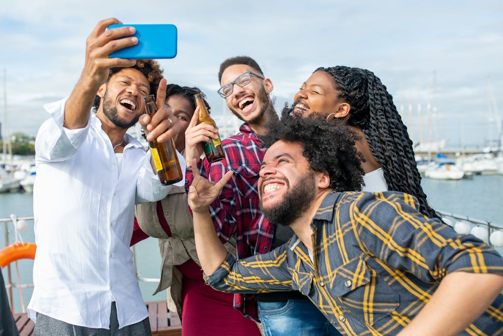 Lively group of friends enjoying a fun time on a yacht in Portugal, capturing memories with a selfie.